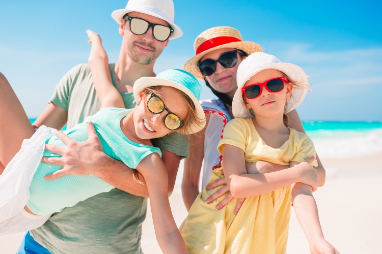 Famille souriante profitant des vacances d'été à la plage
